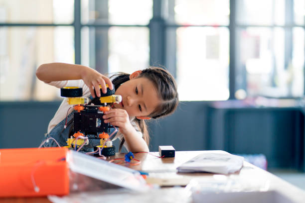 Young student assembling robot